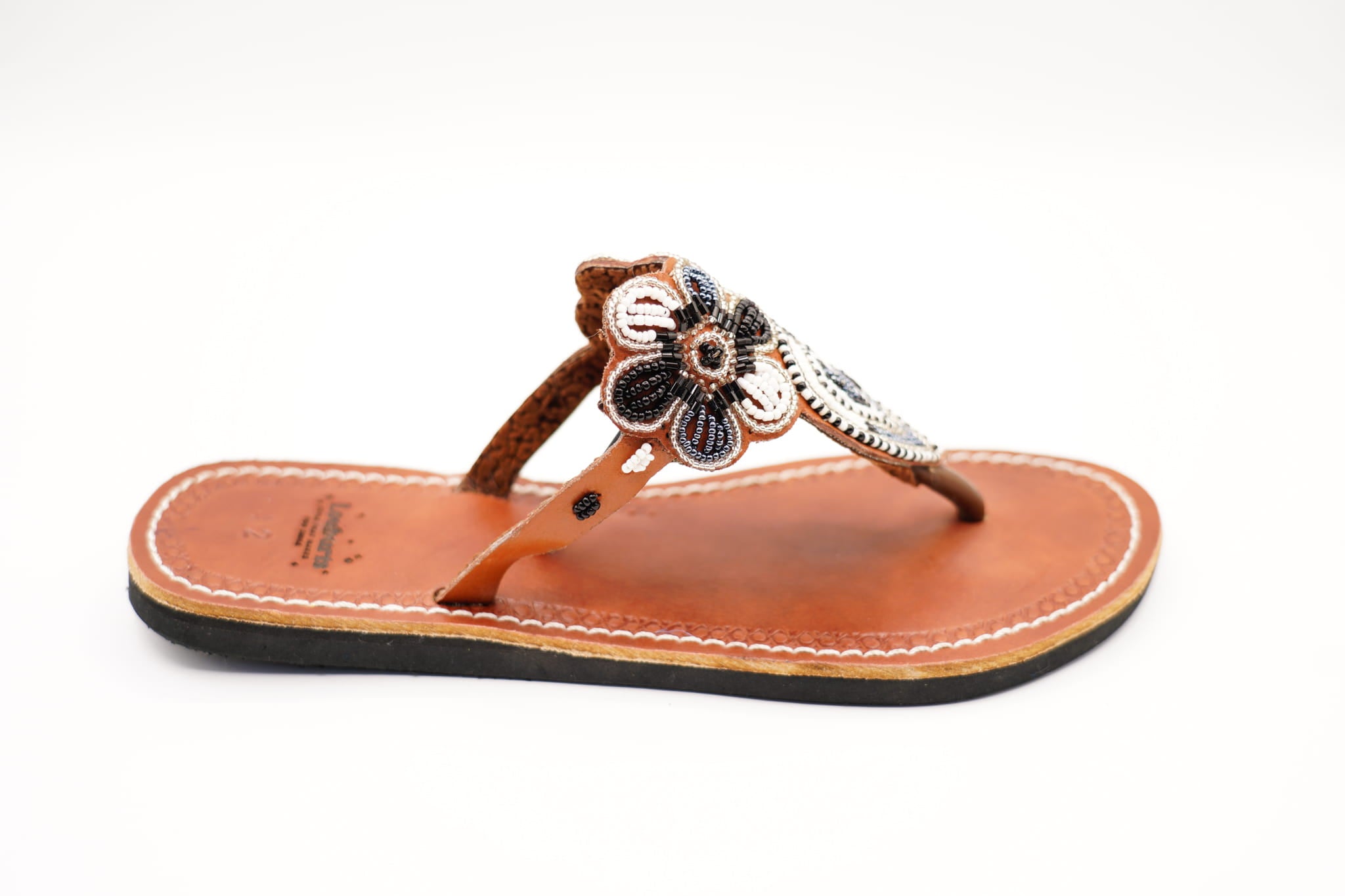 white and black leather sandals profile
